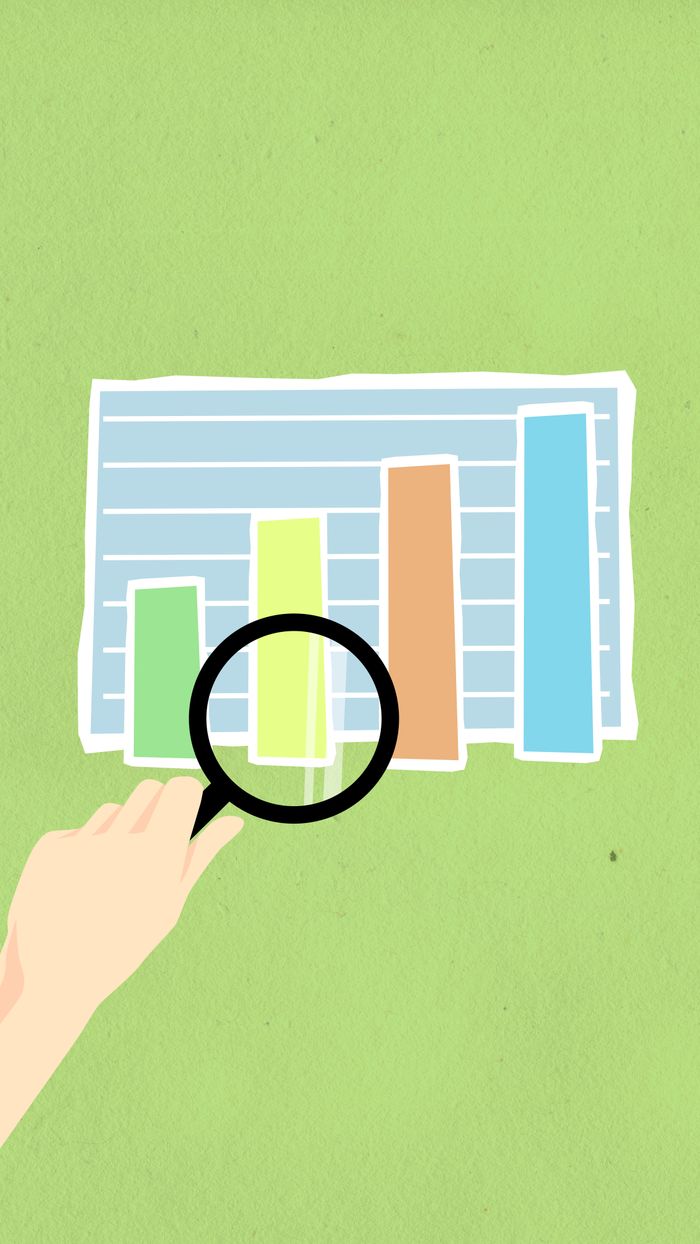 about-02 Top view of decorative cardboard illustration of hand with magnifying glass above diagram with columns on green background